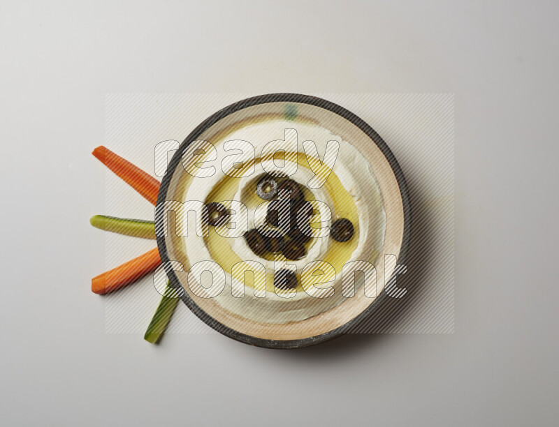 Lebnah garnished with sliced olives in a pottery plate on a white background