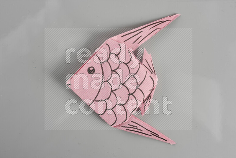 Origami fish on grey background