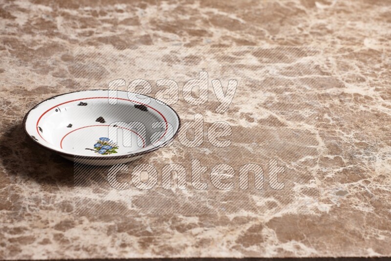 A vintage metal plate on beige marble background
