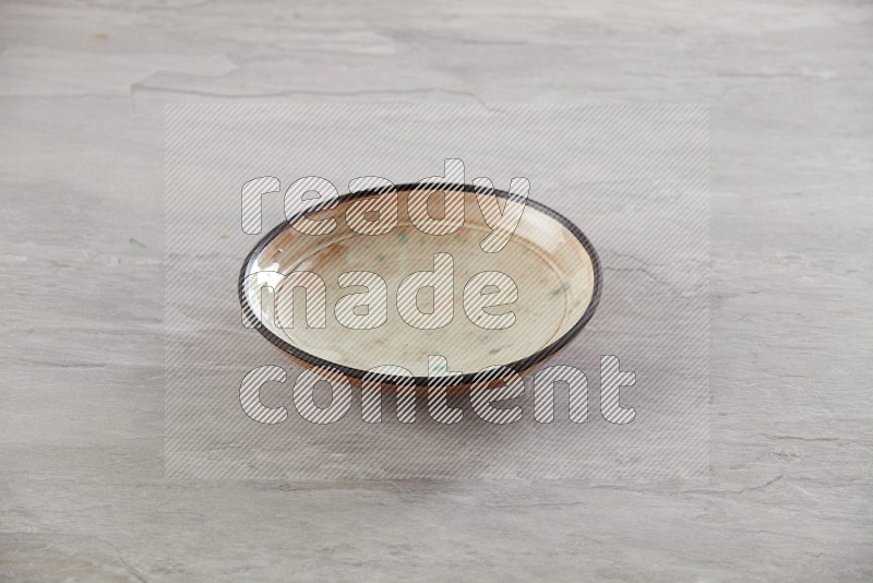 multi color ceramic round plate on grey textured countertop