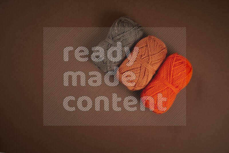 مجموعة من أدوات الخياطة والتفصيل برتقالية اللون على خلفية بنية