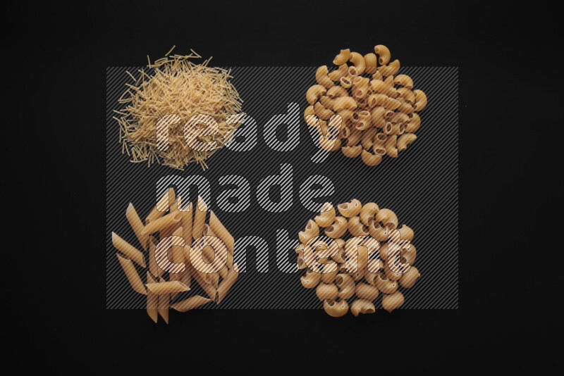 Different pasta types in bunches on black background