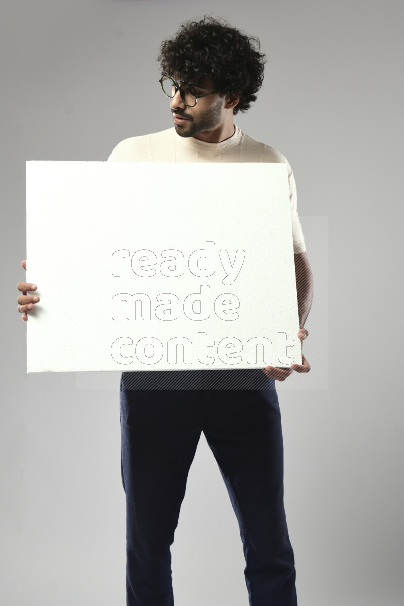 A man wearing casual standing and holding a white board on white background