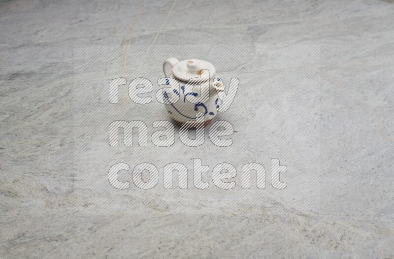A pottery teapot on grey marble background