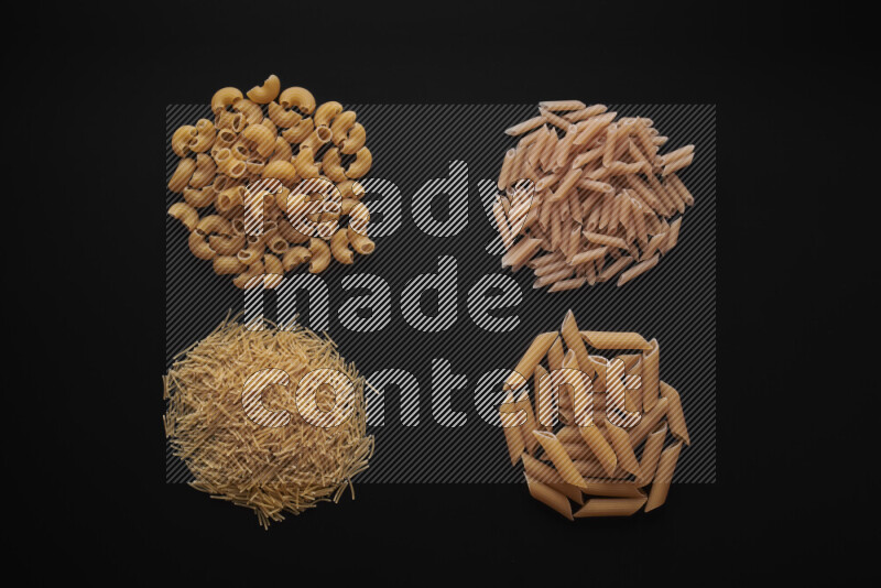 Different pasta types in bunches on black background