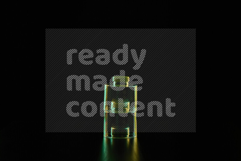 Glassware with rim light in green and yellow against black background