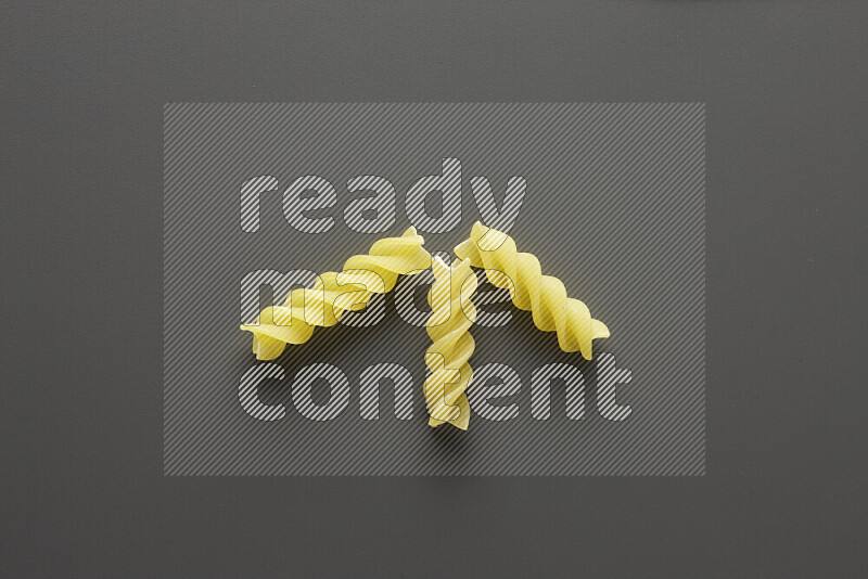 Fusilli pasta on grey background