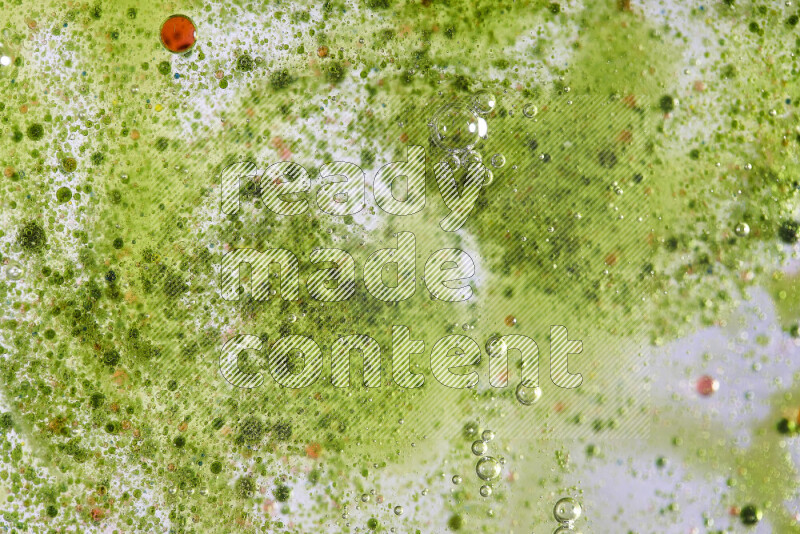 لقطات مقربة لقطرات ألوان مائية حمراء وخضراء على سطح الزيت على خلفية خضراء