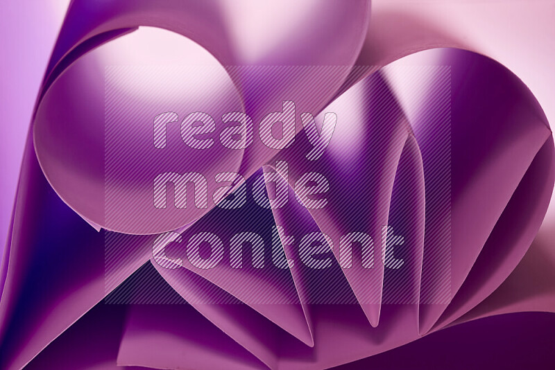 An artistic display of paper folds creating a harmonious blend of geometric shapes, highlighted by soft lighting in purple tones