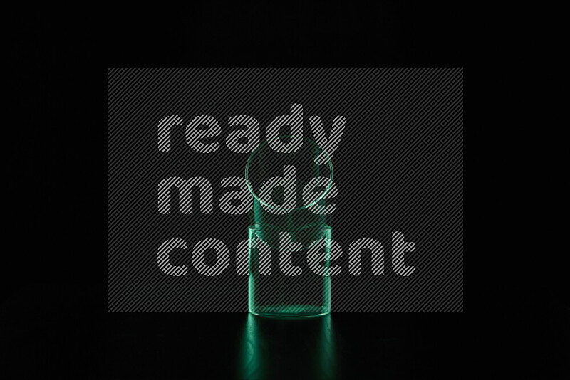 Glassware with rim light in green against black background