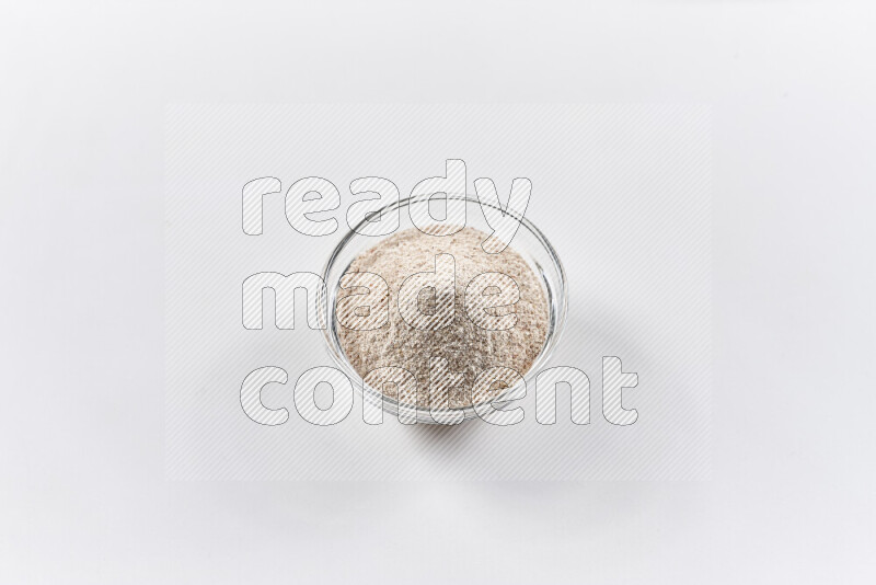 A glass bowl full of onion powder on white background