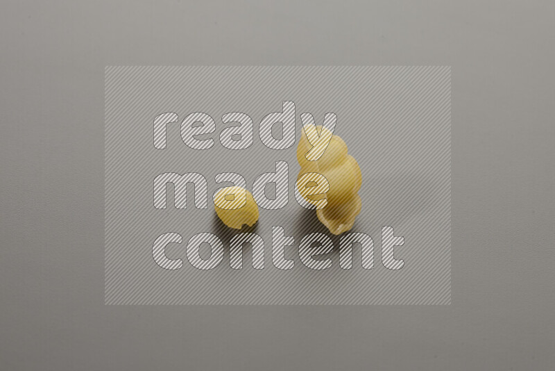 معكرونة ودعة في وعاء فخاري علي خلفية رمادية