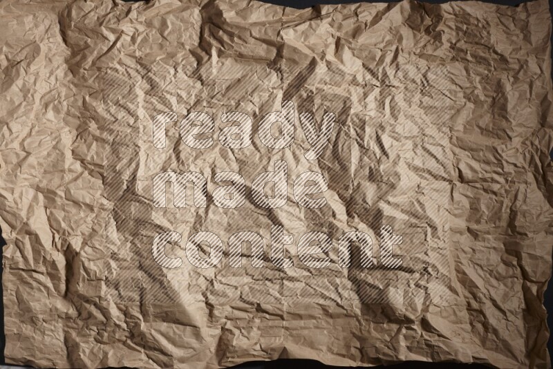 Crumpled craft paper on black background