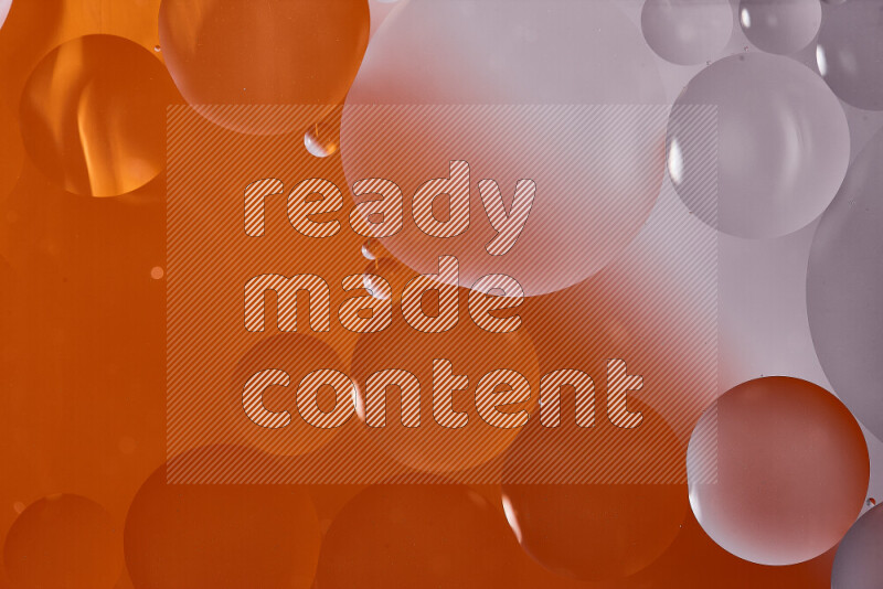 لقطات مقربة لفقاعات من الزيت على سطح الماء باللون الأبيض والبرتقالي