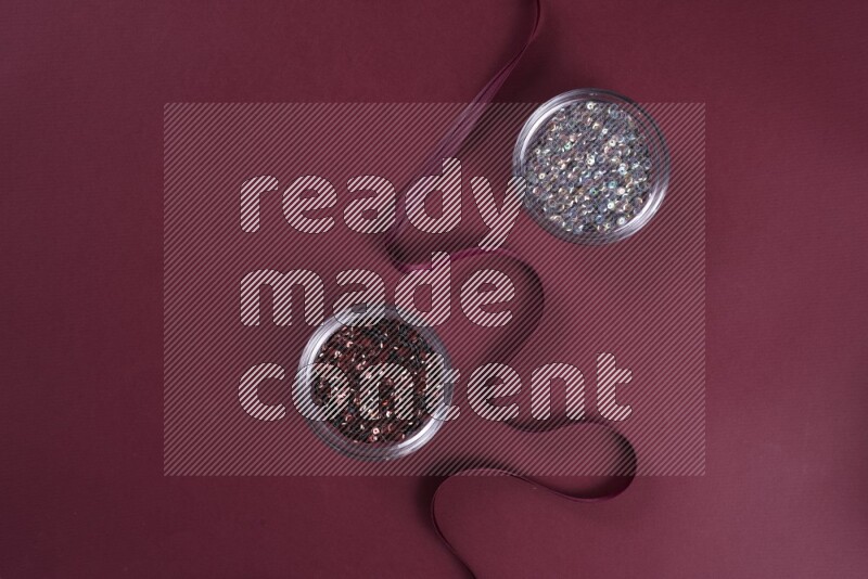 مجموعة من أدوات الخياطة والتفصيل رمادية اللون على خلفية حمراء