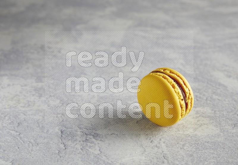 45º Shot of Yellow Lemon macaron on white  marble background