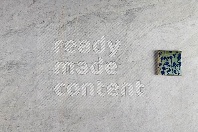 Top View Shot Of A Pottery Coaster tile On Grey Marble Flooring