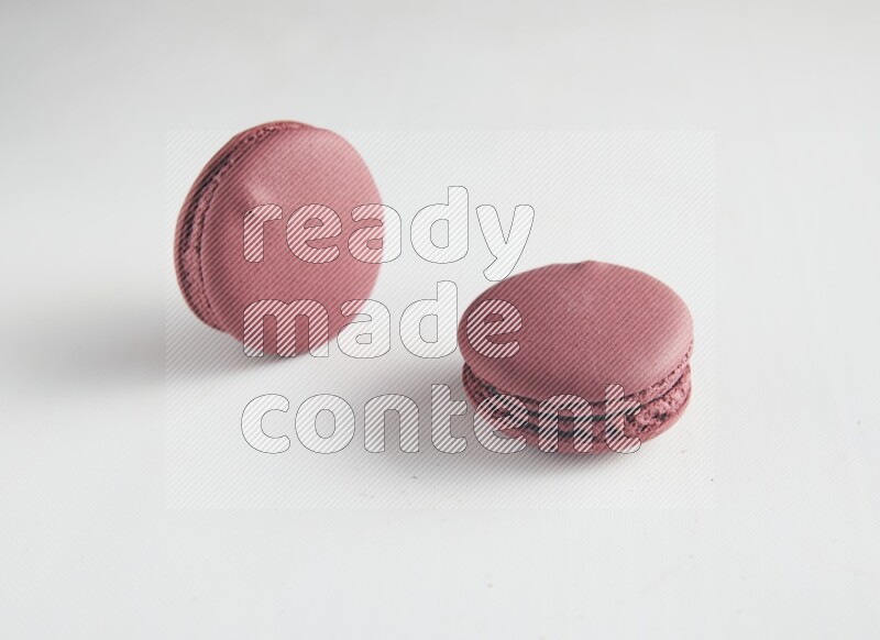 45º Shot of two Red Cherry macarons on white background
