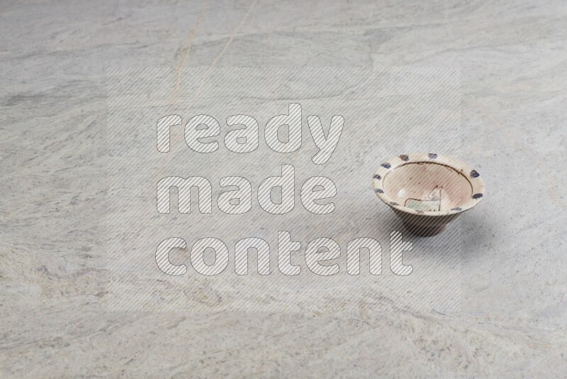 A decorative pottery plate on grey marble background