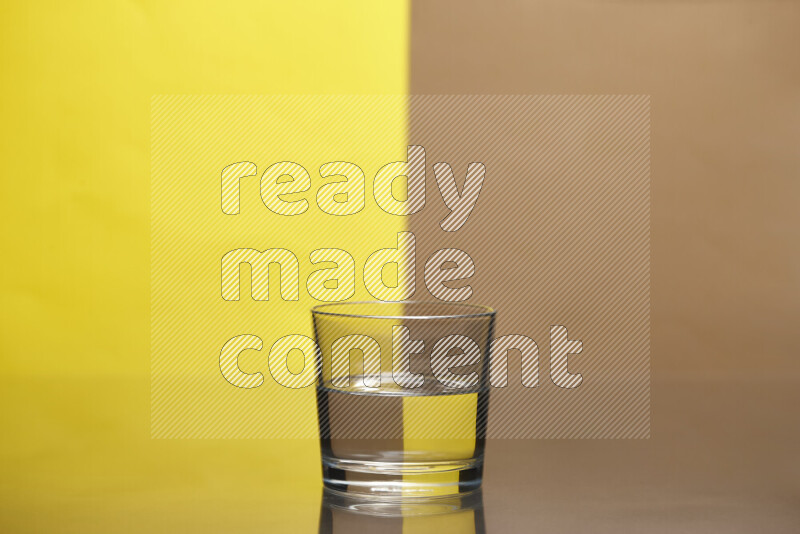 تظهر الصورة أواني زجاجية ممتلئة بالماء موضوعة على خلفية من اللونين الأصفر والبيج