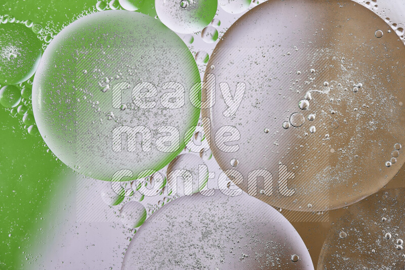Close-ups of abstract oil bubbles on water surface in shades of brown, green and white