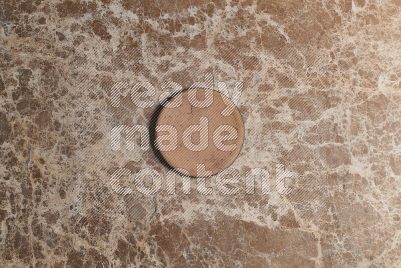 A pottery coaster on beige marble background