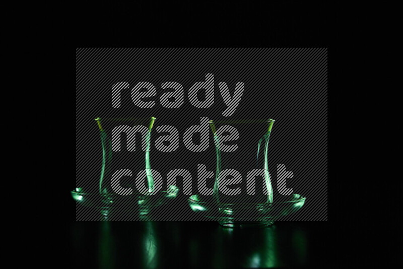 Glassware with rim light in green against black background