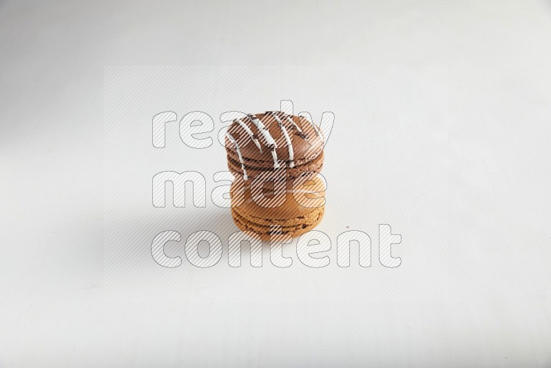 45º Shot of of two assorted Brown Irish Cream, and Brown white Chocolate Caramel macarons on white background