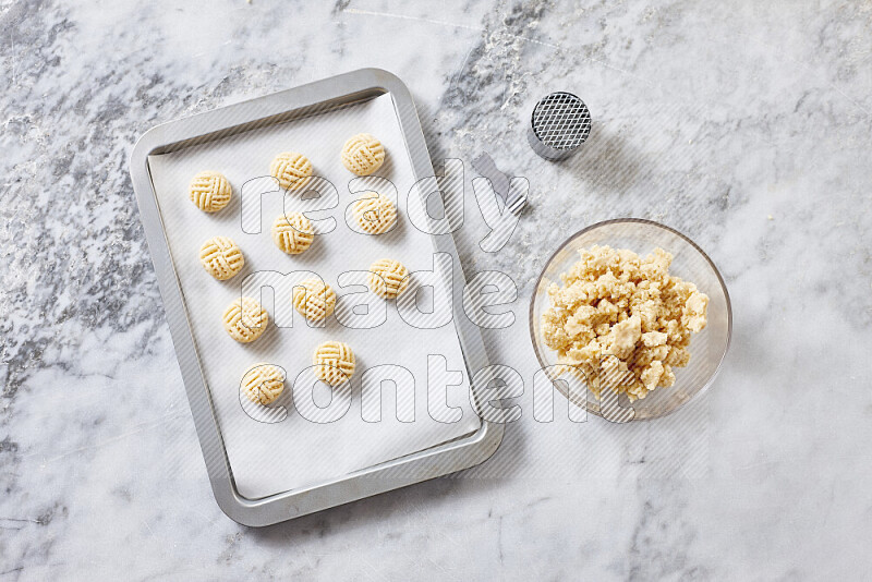 Kahk step by step with its ingredients ghee, sugar, flour, sesame, yeast, water and kahk flavor on grey marble background