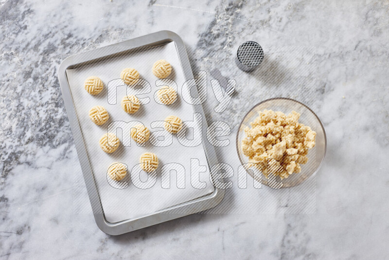 Kahk step by step with its ingredients ghee, sugar, flour, sesame, yeast, water and kahk flavor on grey marble background