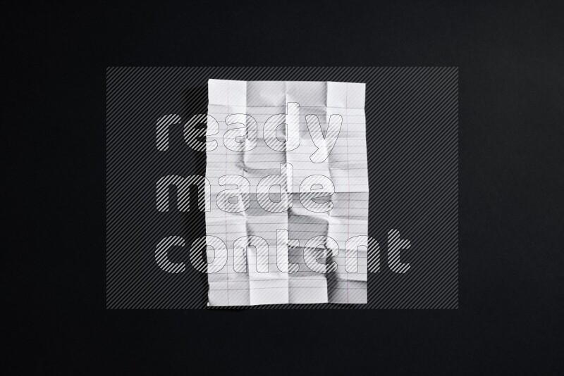 Folded notebook sheet on black background