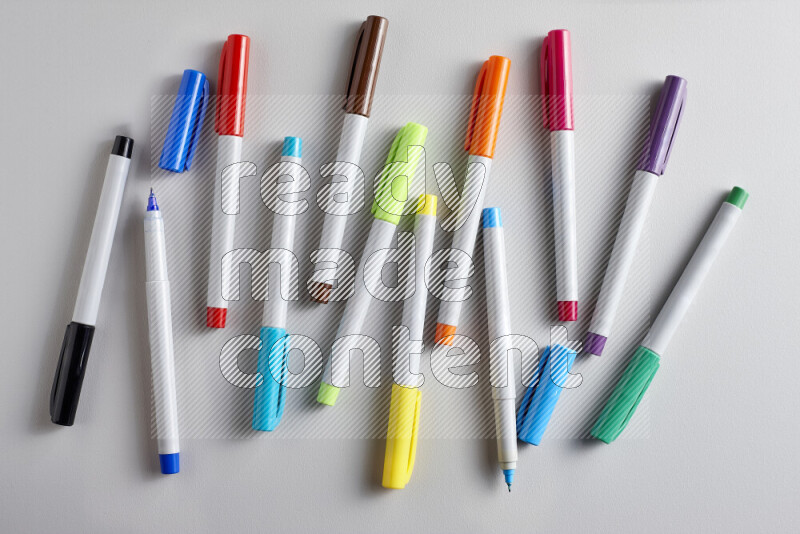 An arrangement of coloring pens in different colors on grey background