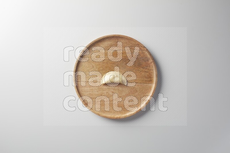 A single Sambosa on a wooden round plate on a white background