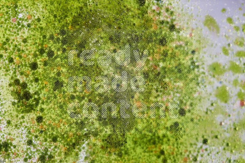 لقطات مقربة لقطرات ألوان مائية حمراء وخضراء على سطح الزيت على خلفية خضراء