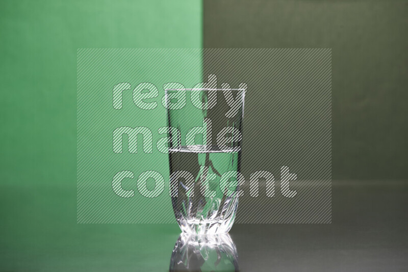 The image features a clear glassware filled with water, set against green and dark green background