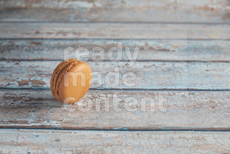 45º Shot of Brown Maple Taffy macaron on light blue wooden background