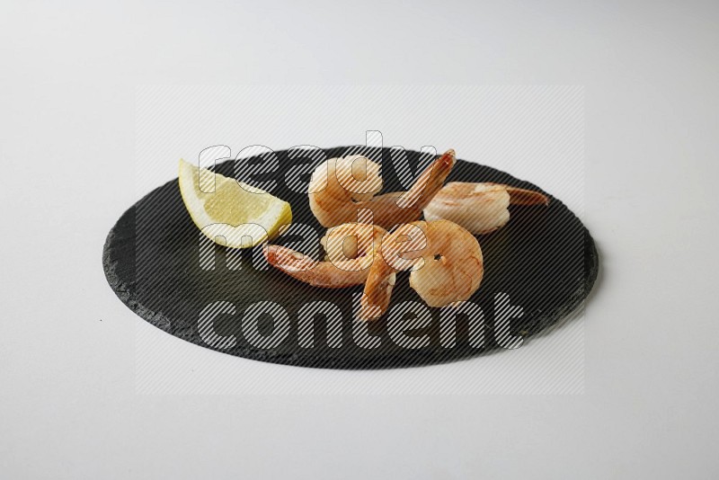 four grilled shrimp  on a black slate direct  on a white back ground