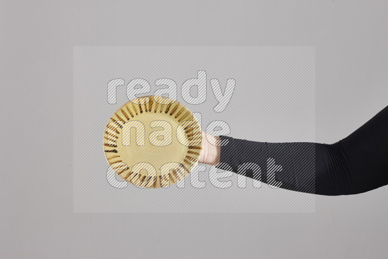 A woman in black abaya holding different pottery essentials in different positions