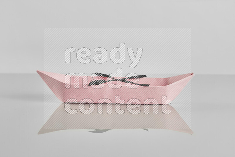 Origami boat on grey background