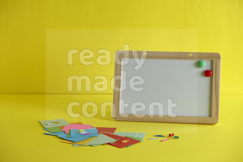 A whiteboard with different school supplies on yellow background