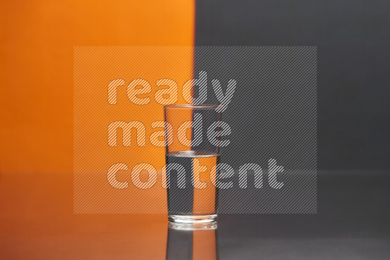 The image features a clear glassware filled with water, set against orange and black background