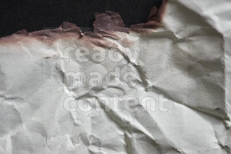 Burnt multicolored paper on black background