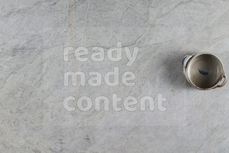 وعاء فخاري متعدد الألوان على خلفية من الرخام الرمادي