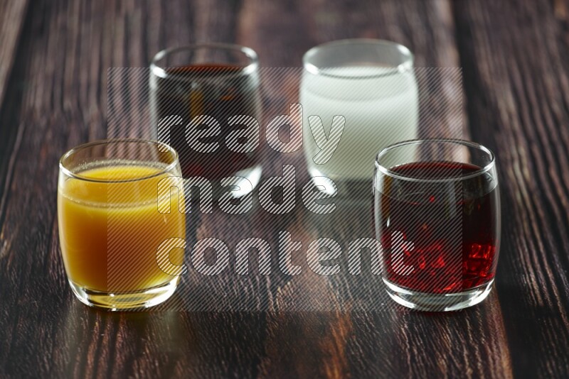 Cold drinks in a glass cup such as water, tamarind, qamar eldin, sobia, milk and hibiscus on wooden background