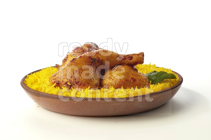 yellow basmati Rice with kabsa chicken pieces on a pottery plate direct on white background