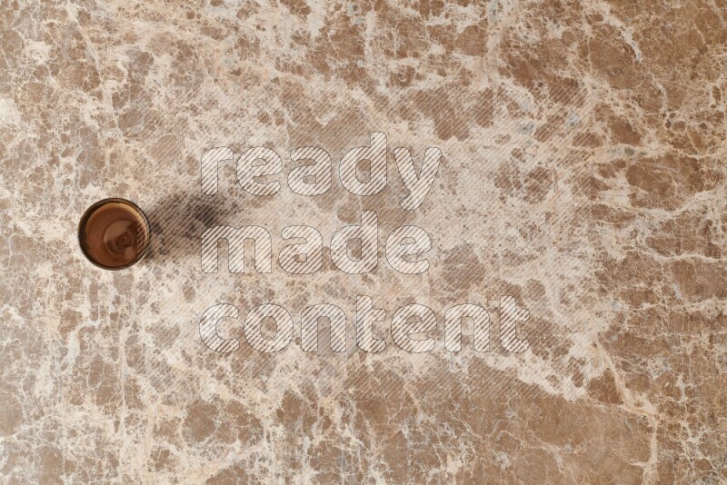 A pottery cup on beige marble background