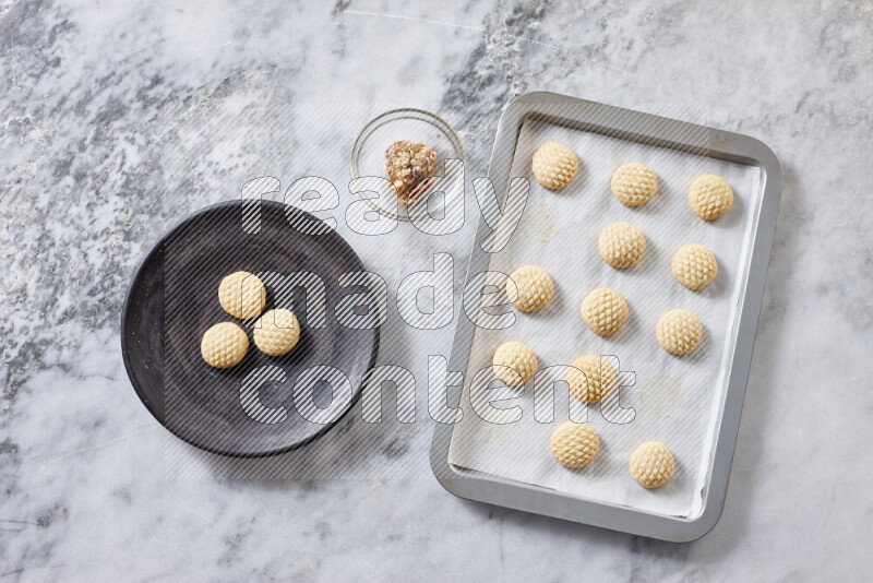 Kahk step by step with its ingredients ghee, sugar, flour, sesame, yeast, water and kahk flavor on grey marble background