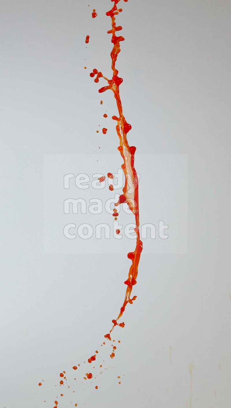Orange liquid splash and drops on white background