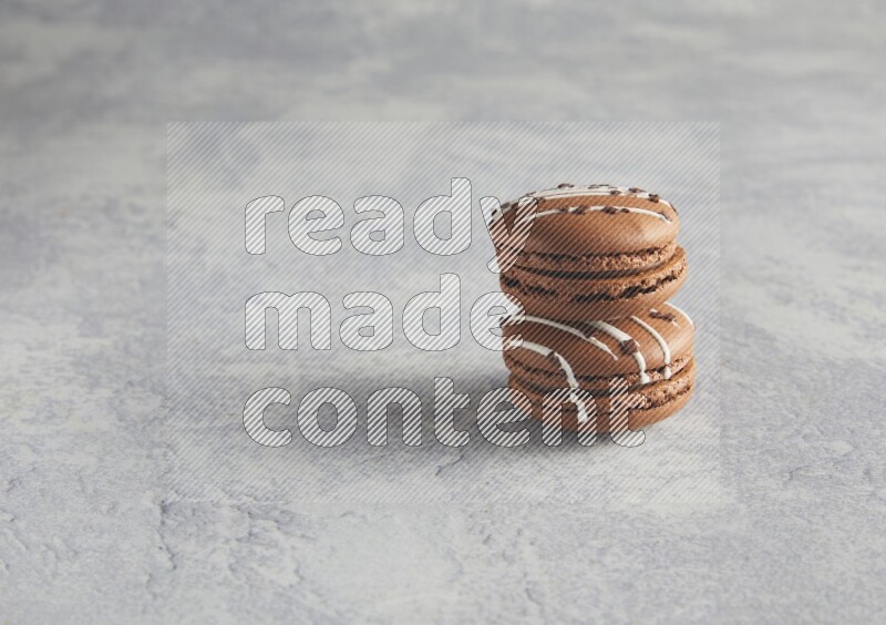 45º Shot of two Brown white marbleChocolate Caramel macarons  on white  marble background
