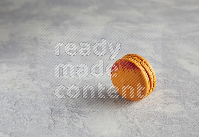 45º Shot of Orange Exotic macaron on white  marble background